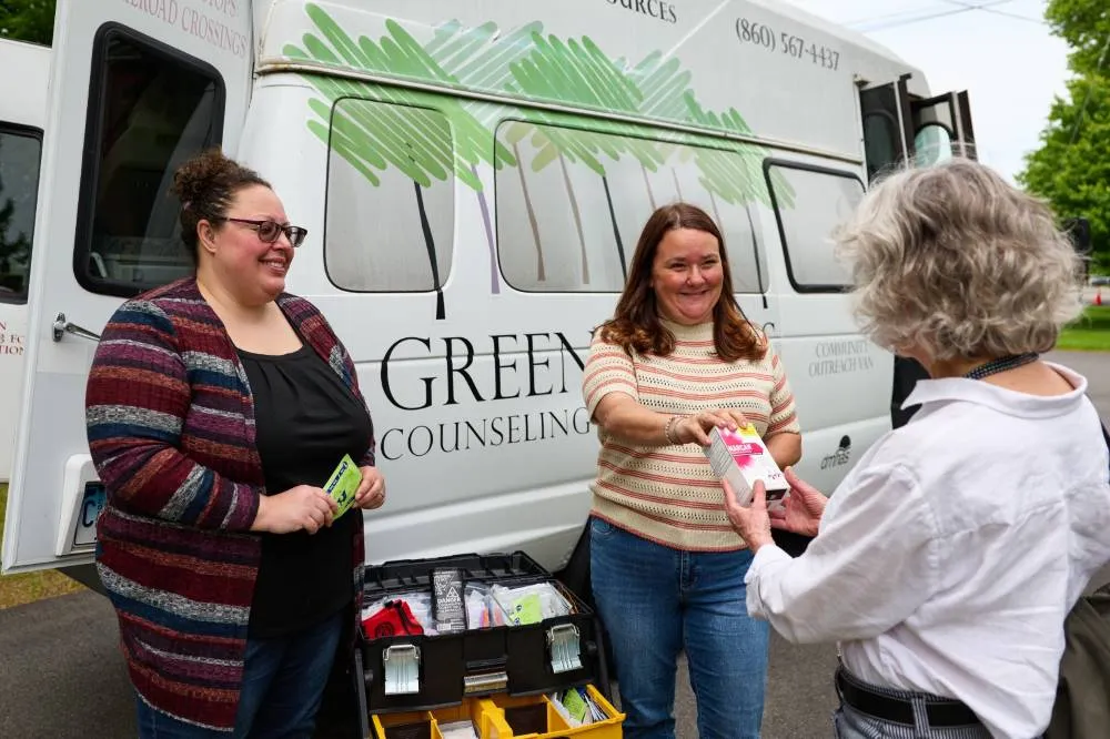 Greenwoods Community Outreach team handing out supplies beside the Greenwoods outreach van